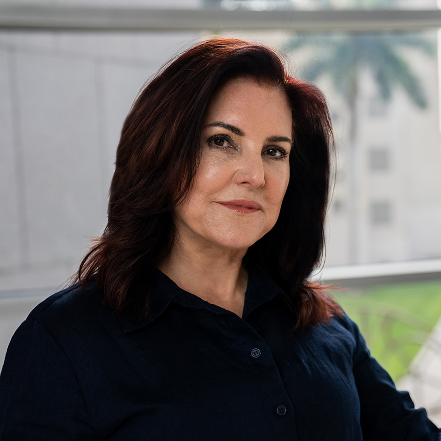 Woman with brown hair posing for a photo in front of art.