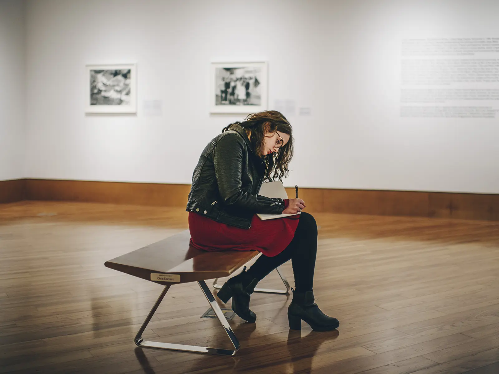 FIU student draws on a sketchpad in an indoor gallery at the Frost Art Museum