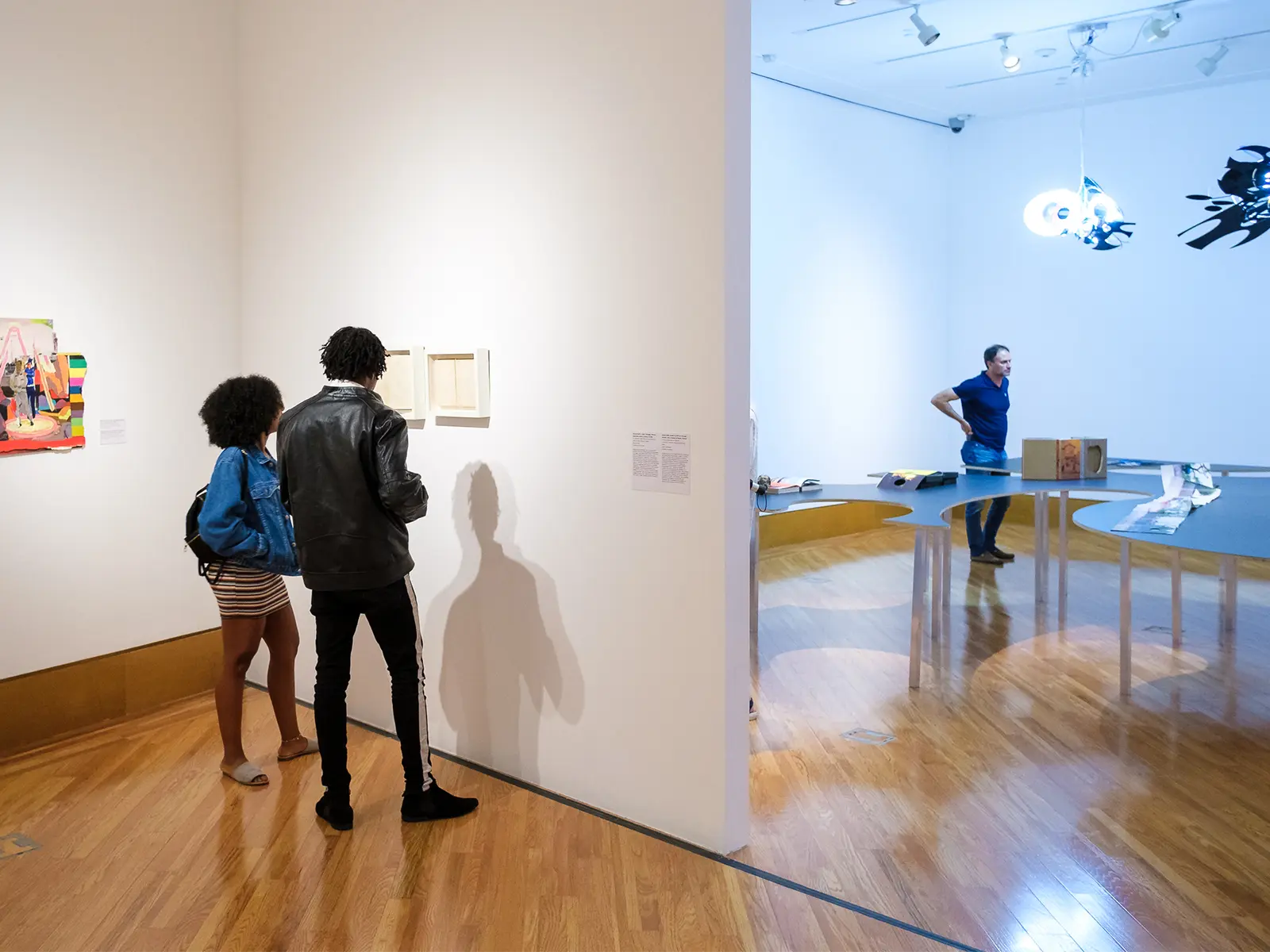 Visitors observing artwork in galleries at Frost Art Museum