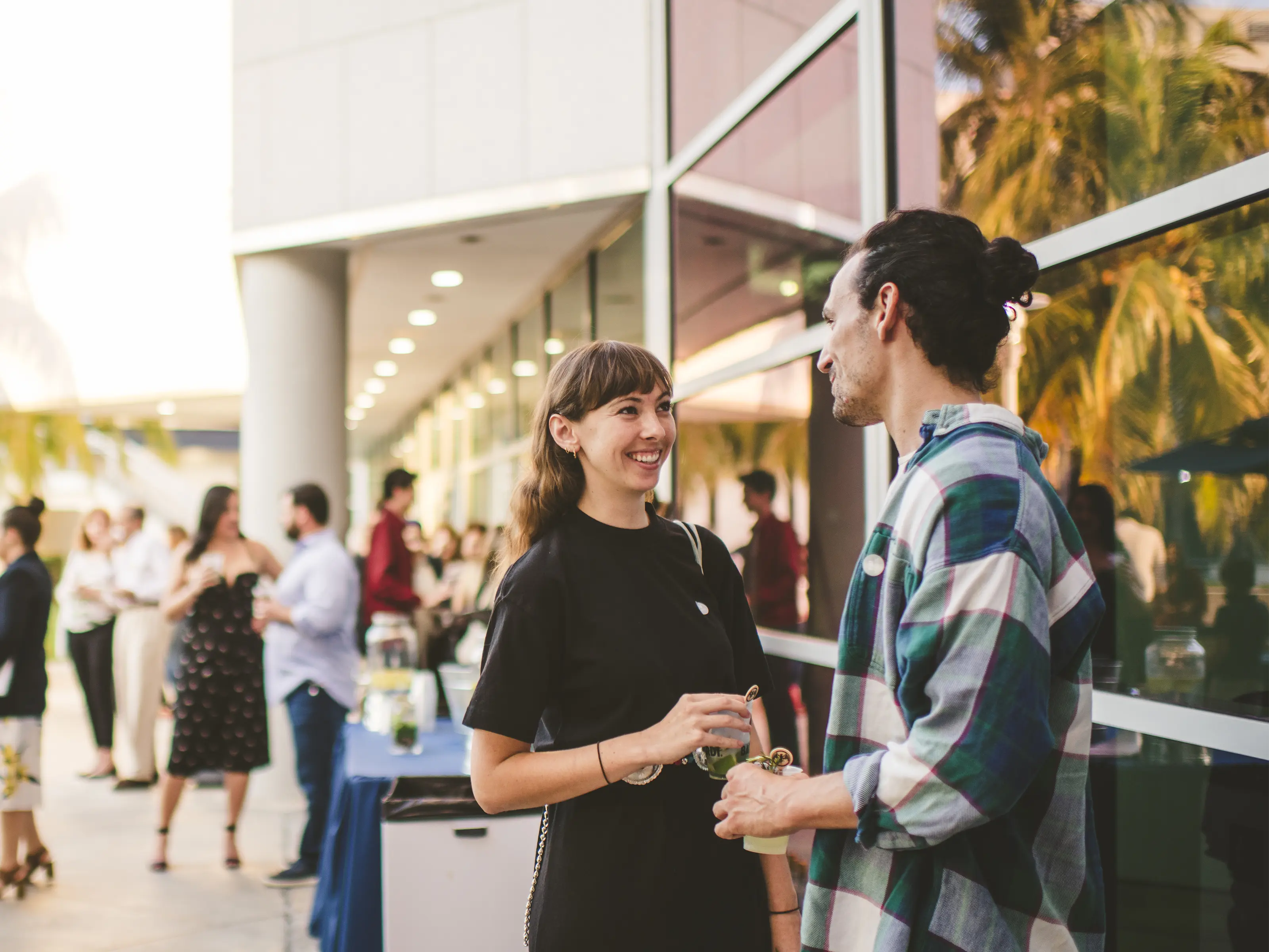 A couple chats over a table overlooking a museum outdoor terrace