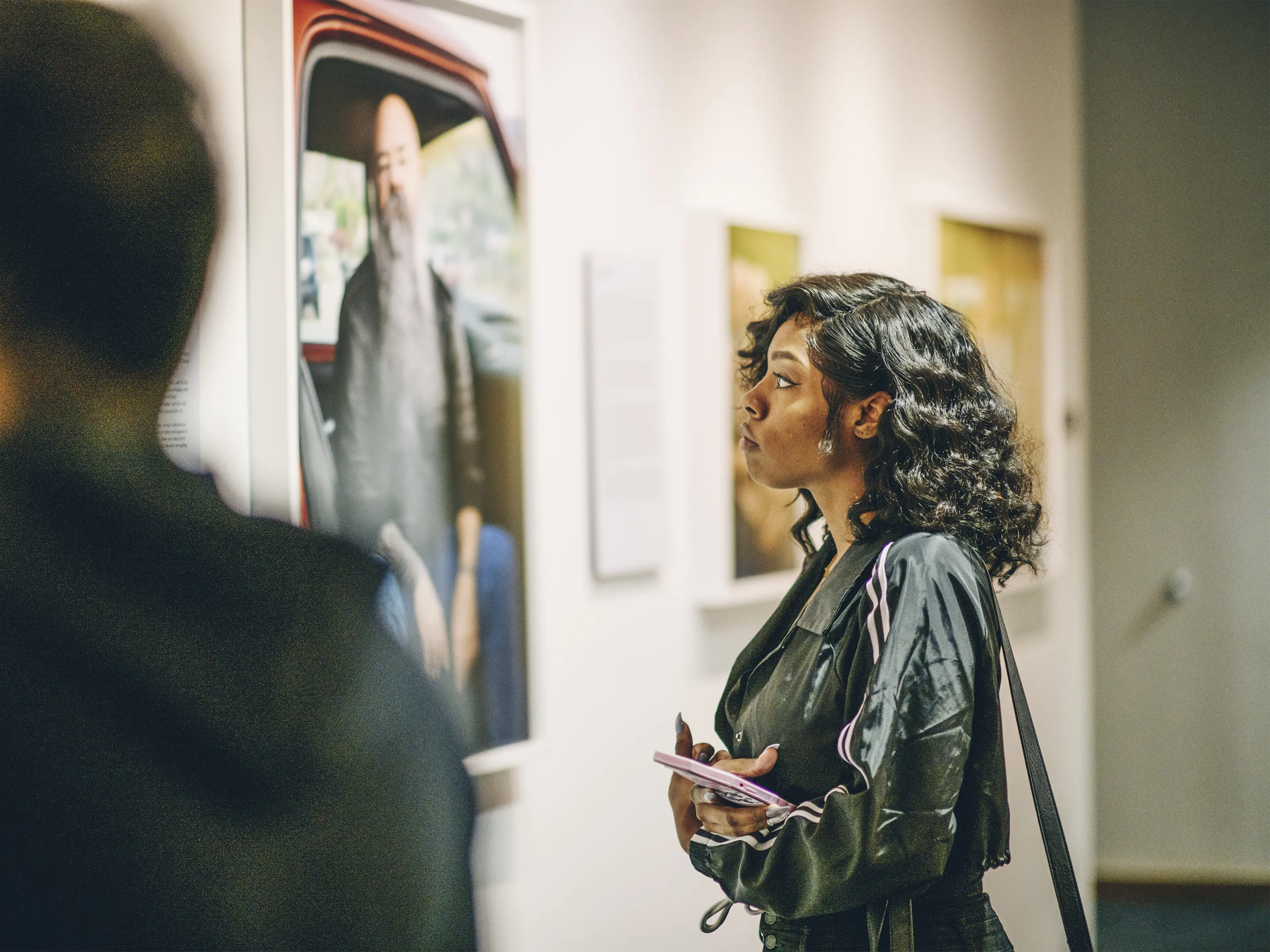 A woman observes a large photograph in a museum gallery